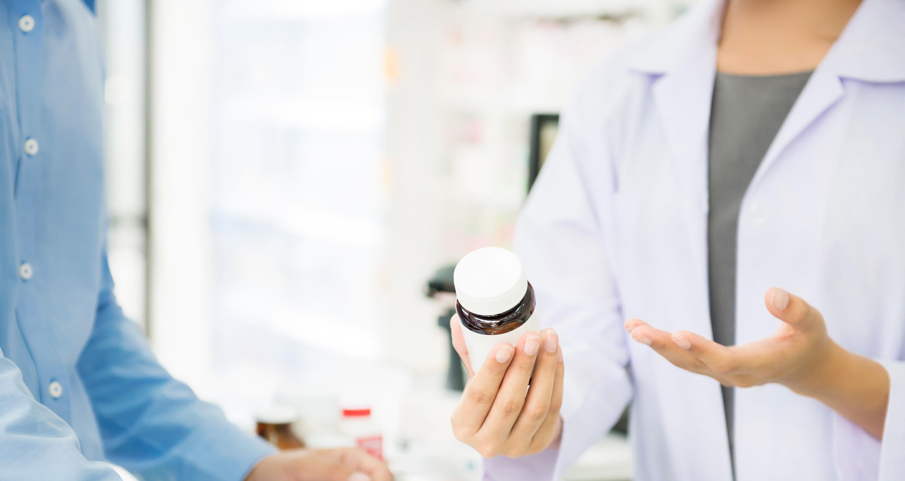 Apotheker erläutert die Nebenwirkungen eines Medikamentes