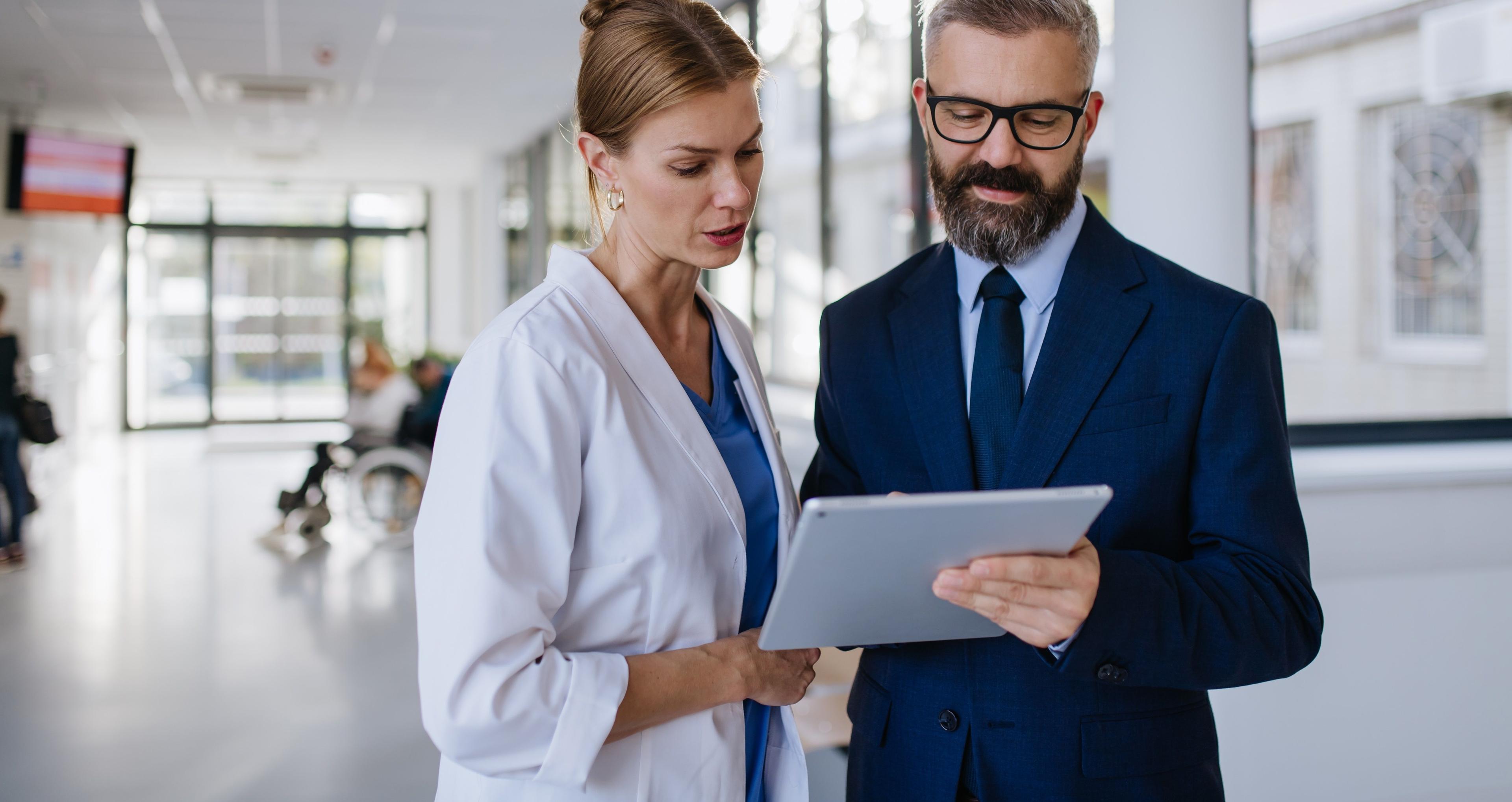 Ärztin im leitenden Dienst tauscht sich mit Direktor zum Thema Health Management im Krankenhaus aus