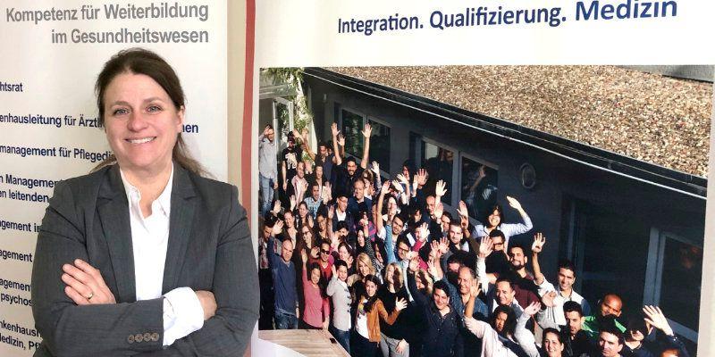 Frau Dr. Theusinger steht vor einem Roll-Up der mibeg-Institute Medizin