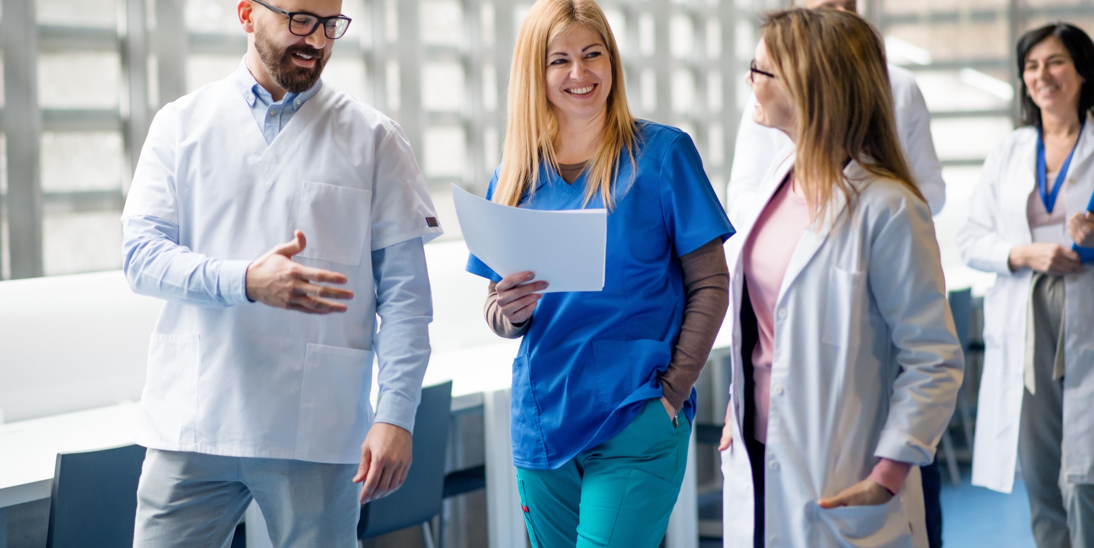 Mitarbeiter des Managements psychatrischer und psychosomatischer Kliniken tauschen sich auf einem Flur aus