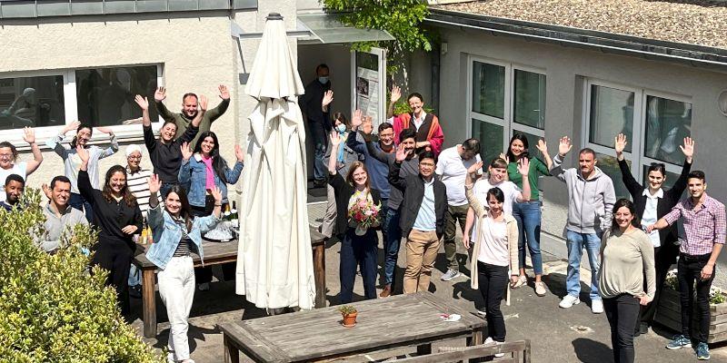 Teilnehmer des hundertsten Seminars für Qualifizierung in Klinik und Praxis winken in die Kamera