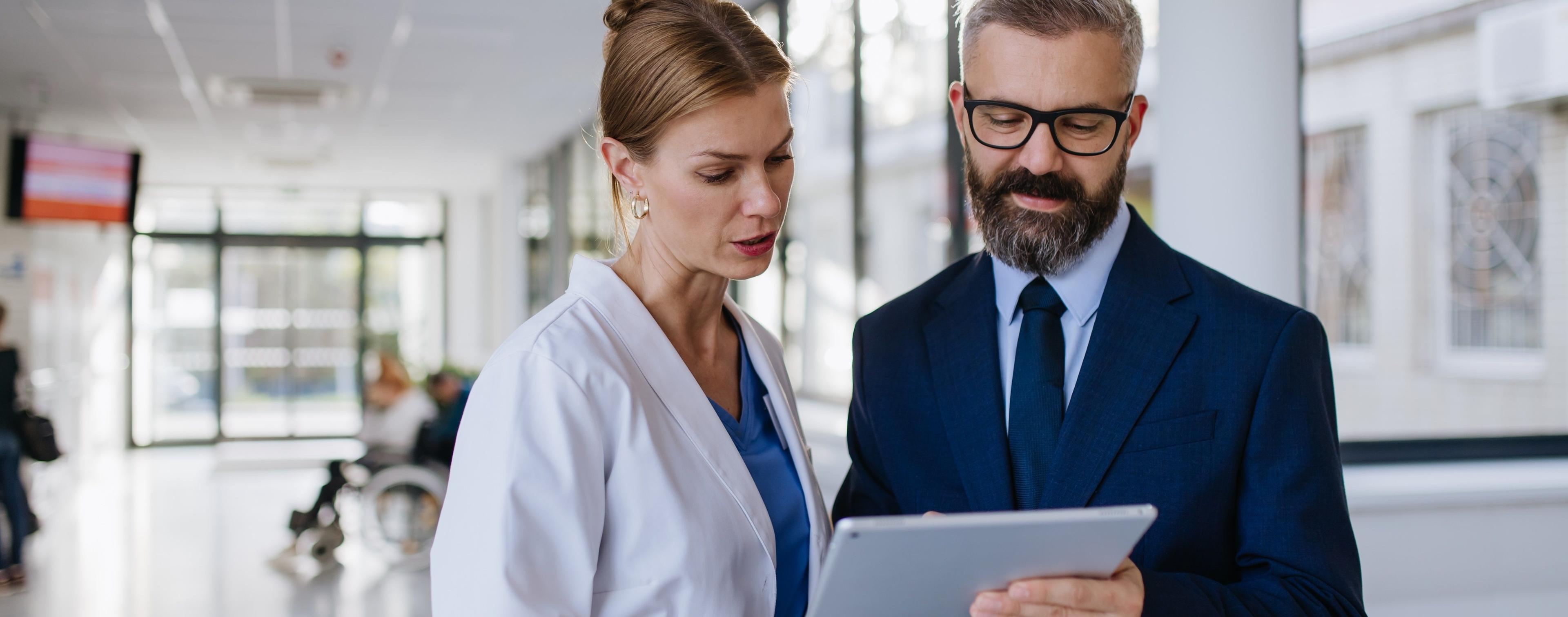 Ärztin im leitenden Dienst tauscht sich mit Direktor zum Thema Health Management im Krankenhaus aus