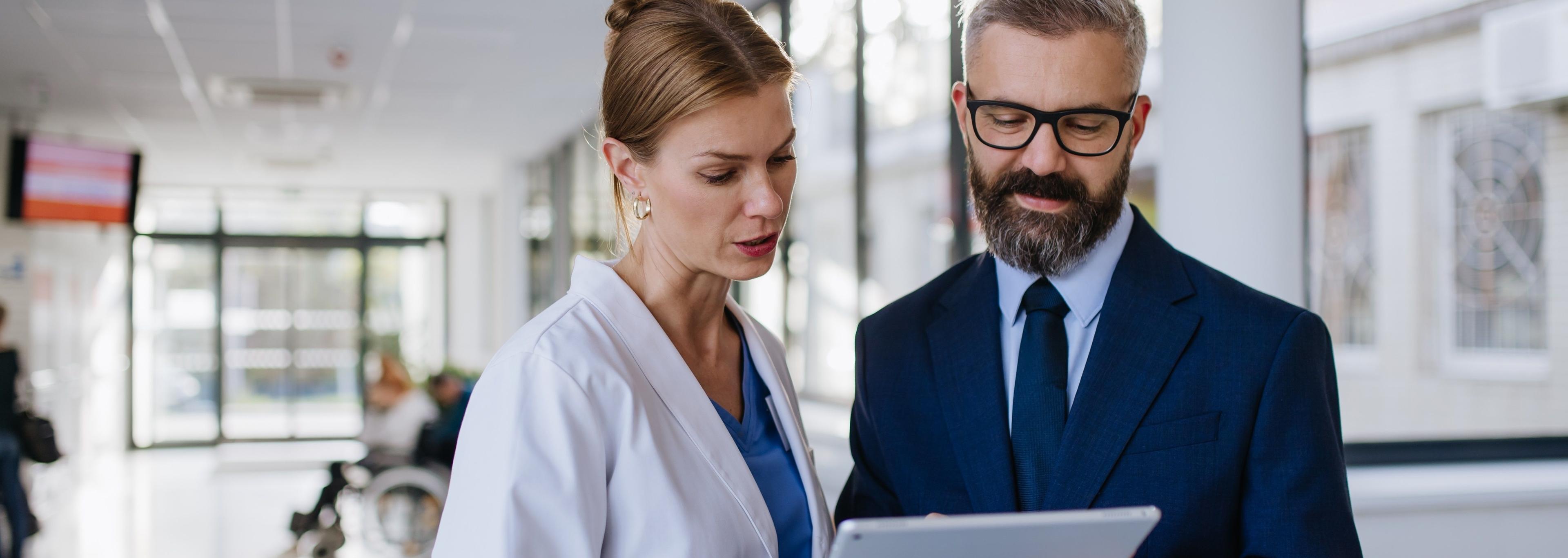 Ärztin im leitenden Dienst tauscht sich mit Direktor zum Thema Health Management im Krankenhaus aus